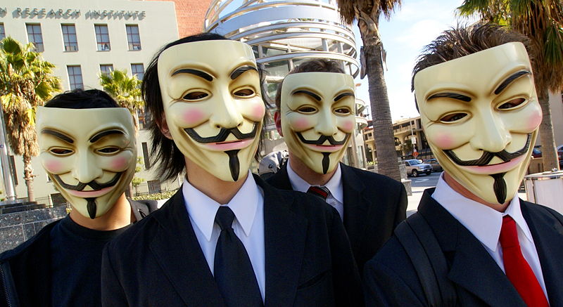 Anonyymejä nyyminaamio päässään Scientologiaraidin aikana